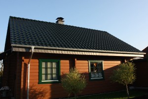 Holzhaus mit dunkelgrünem Dach
