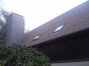 Haus mit Holzfassade und braunrotem Dach