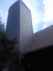 Haus mit Holzfassade und Braunrotem Dach