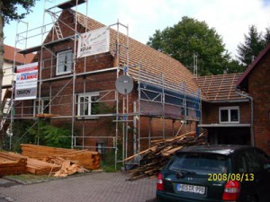 Backsteinhaus ohne Dachpfannen mit Baugerüst