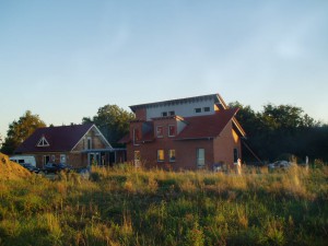 Zwei Häuser; davor eine Wiese