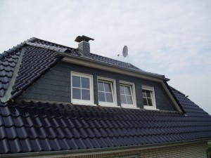Schwarzes Dach mit 3-Fenster-Erker