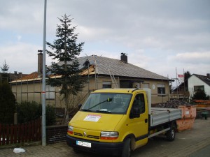 Beiges Haus mit freigelegtem Dach; davor ein Hannig Firmenfahrzeug