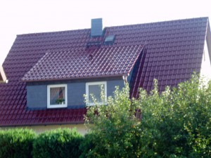 Weißes Haus mit dunkelrotem Dach