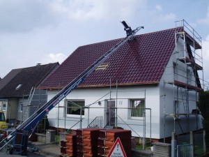 Ein Dachdeckeraufzug bringt die Pfannen aufs Dach