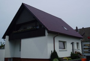 Weißes Haus mit dunkelrotem Dach