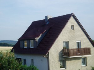 Weißes Haus mit dunkelrotem Dach