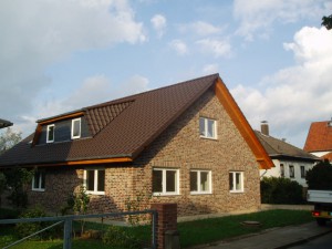 Beigerotes Haus mit braunem Dach