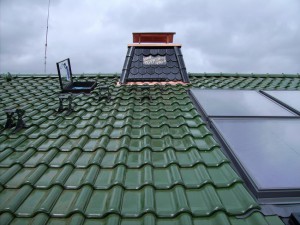Grünes Dach mit schwarzem Schornstein