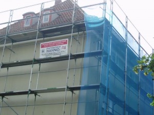 Gelbes Haus mit rotem Dach und Baugerüst